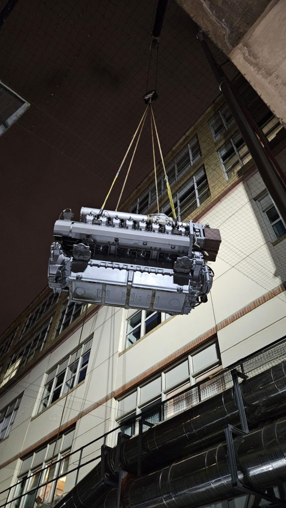 Engine being lifted outdoors